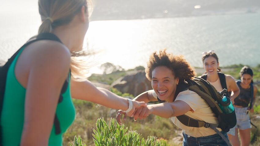 Girls day out ideas: group of women helping each other while hiking